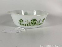 Side angle view of the white glass casserole dish showing the green floral pattern around sides.