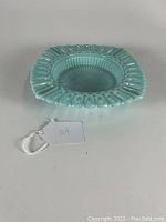 Front view of vintage blue opaline dish showing circular ribbed center and reticulated edge design with attached lot number tag.