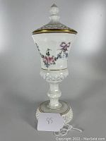 Front view of the Westmoreland Glass English Hobnail Milk Glass Painted Footed Covered Candy Jar showing floral painted details and gold accents on the rim and lid.