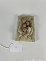 Photo of first Willow Tree family portrait plaque with four embracing figures, carved resin with tree motif