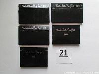 Five black United States Proof Set packages labeled with years 1977, 1978, 1979, 1980, and 1982.