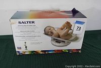 Original box of the Salter electronic baby and toddler scale showing a baby lying in the tray and product branding.
