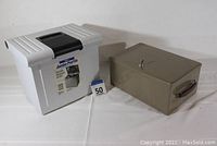 Both the steel storage box safe and plastic document holder shown side by side on a white surface