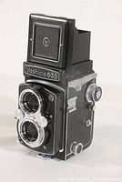 Front and side view of Yashica 635 twin lens reflex camera showing lens and shutter controls.