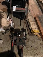 Mantis Tiller with handlebar, engine, wheels, and controls in storage area