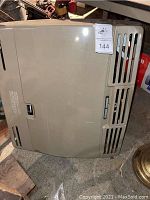 Front view of beige metal Orbis Mark Series heater with vent slats and identification label
