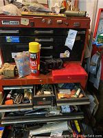 Red PowrKraft chest atop black toolbox, drawers open with mixed tools