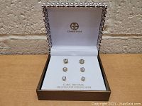 Front view of the three pairs of stud earrings in a Giani Bernini box showing cubic zirconia stones and gold overlay.