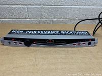 Front view of Behringer BTR2000 rack tuner showing control knob, LED display, input/output jacks, and footswitch port.