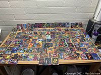 Wide overhead view of the entire collection of Marvel comic collector cards spread out on a table.