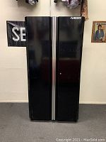 Front view of black two-door Husky steel garage cabinet with vertical silver handles and Husky logo on top right door.