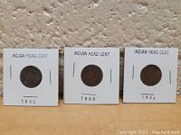 Front view of 3 Indian Head cents dated 1895, 1903, and 1904 in cardboard holders