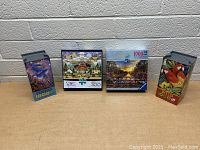 Four unopened jigsaw puzzles in original packaging showing front covers and piece counts (1000 and 300).