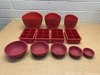 Photo of all red silicone kitchen items including measuring cups, molds, and bowls arranged on a table.