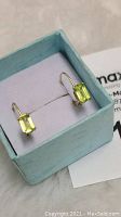 Pair of 10k gold earrings with rectangular emerald-cut peridot gemstones displayed in a light blue jewelry box.
