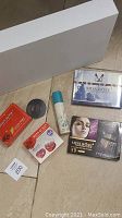 Photo showing white gift box with assorted new makeup items placed in front including Miss Rose and MY Eyelashes products