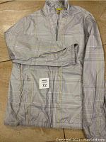 Front full view of gray plaid Nike jacket laid flat showing overall design, zipper, collar, and sleeve detail
