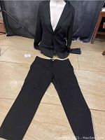 Black Missguided blazer and black J. Crew pants laid on floor showing front of both items.