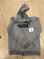Front view of the grey Puma hoodie with visible logo and zipper. Medium size tag visible.