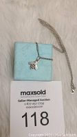 Sterling silver bee pendant necklace on a light blue jewelry box, with auction label visible.