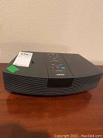 Front view of black Bose Wave Radio showing its curved design and control panel on top.