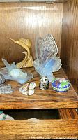 Wooden shelf with frosted glass butterfly, frosted bird on leaf, brass marlin, pewter castle, cloisonné boxes