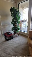 Full view of artificial tree with planter and wooden stand