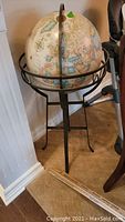 Full view of the globe on a black metal stand showing the overall size and design