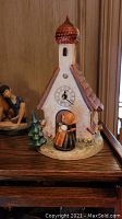 M.J. Hummel church clock figurine depicting a small white church with red roof, clock face, and a figure in front door.