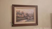 Full view of framed Thomas Kinkade artwork hanging on wall.