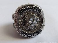 Top view of the Chicago Blackhawks replica Stanley Cup championship ring showing the Blackhawks logo and 'STANLEY CUP CHAMPIONS' inscription with rhinestones.