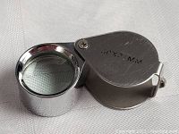 Photo showing the jeweler's loupe open, metal housing marked with "30X21MM".