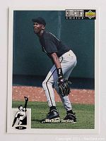 Front side of Michael Jordan baseball card showing him fielding with glove, wearing black and gray uniform.