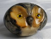 Close-up view of the small alabaster owl showing natural color variations and facial detail.