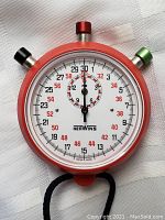 Close-up of red Herwins stopwatch face showing detailed markings and brand name
