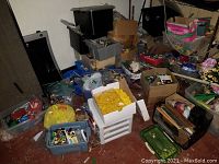 Floor view showing multiple storage containers (gray tub, white drawers, cardboard boxes, yellow bag) filled with assorted LEGO pieces