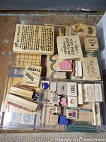 Top view of a tray containing small to medium-sized rubber stamps with text and decorative motifs.