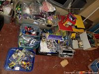 Overview of multiple tubs, buckets and boxes filled with assorted LEGO bricks and parts
