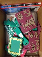 Box with assorted rubber stamps showing colorful stamps with green handles and shapes like anchor, captain's wheel, and other cutouts.