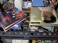 Top view of multiple vinyl records stacked, showing Robert Goulet and The Cool Gang among others.
