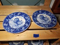 Two blue and white porcelain plates with turkey and floral patterns shown from front.