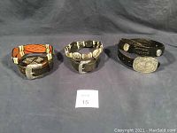 Three black leather western style belts laid out, showing overall condition and design.