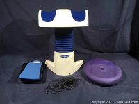 FitterFirst seat cushion, Blue and white plastic Back2Life adjustable back massager, purple balance disc, and black wired electric control. Blue and black fabric ice pack holder laid out.