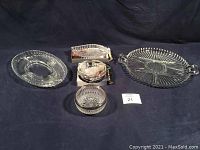 Five glassware items including two sectioned platters and three small candy dishes with plated rims and decorative details, some with boxes
