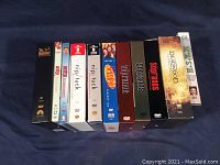 Front view photo of all 12 DVD box sets lined up, showing various titles and seasons from TV series including Dexter, Nip/Tuck, Seinfeld, Sopranos, Deadwood, and MASH.