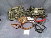 Overview photo showing two handbags and six belts laid out on surface