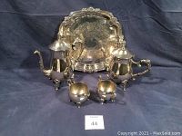 Full view of vintage silver plated coffee and tea service including tray, showing coffee pot, tea pot, sugar, creamer, and tray on dark cloth background.