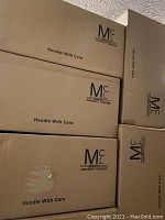 Stacked cardboard boxes labeled Mario Contract Lighting, marked "Handle With Care" indicating original packaging for the lamps.