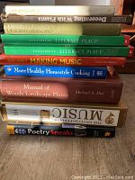 Stack of 10 varied hardback books with titles related to music, cooking, literacy, plants, and poetry.