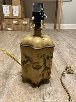 Photo of a single accent lamp base showing detailed floral and bird design with lamp hardware.